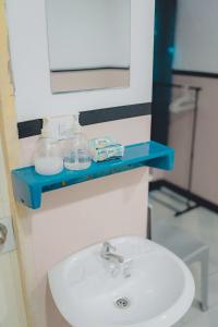 a bathroom sink with a blue shelf above it at Mitr Inn Phuket Oldtown in Phuket Town