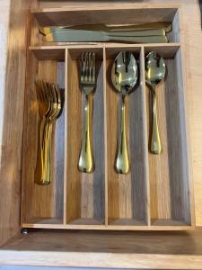 four gold forks and spoons in a wooden drawer at Luxury Tiny Cottage 5 miles from Disney in Kissimmee +6 photos