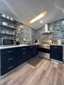 a large kitchen with blue cabinets and a stove at Luxury Tiny Cottage 5 miles from Disney in Kissimmee