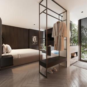 1 Schlafzimmer mit einem Bett und einem Ankleidezimmer in der Unterkunft PureJoy Hotel Saigon in Ho-Chi-Minh-Stadt