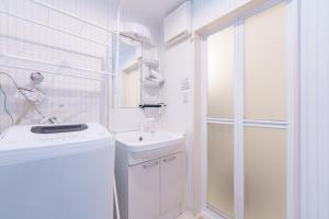 ein weißes Badezimmer mit Waschbecken und Dusche in der Unterkunft 6 min to Nagoya Brand-new building Sleeps 5 in Nagoya
