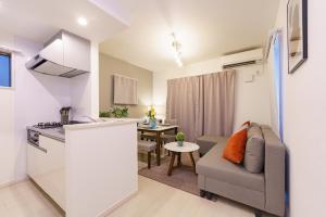 eine Küche und ein Wohnzimmer mit einem Sofa und einem Tisch in der Unterkunft 6 min to Nagoya Brand-new building Sleeps 5 in Nagoya