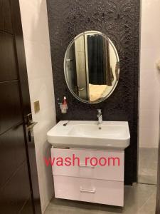 a bathroom with a sink and a mirror on a wall at H and J in Lahore
