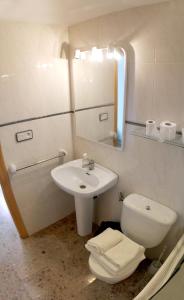 a bathroom with a sink and a toilet and a mirror at Casa Rural Martina in Guadalaviar