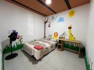 1 dormitorio con 1 cama con animales en la pared en Casa vacacional de 2 pisos en Restrepo, Meta, en Restrepo