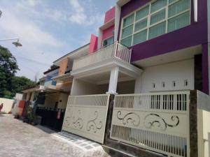 a purple and white house with a balcony at guest host Rumah Yoga in Gonurong