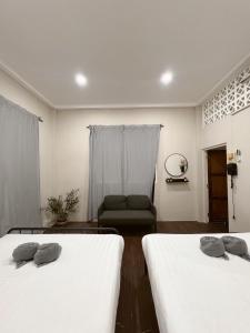 two beds in a room with a couch at Tolomhouse in Hat Yai
