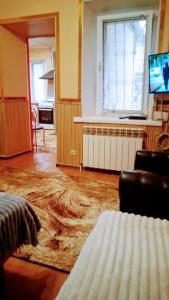 Una sala de estar con un sofá, una mesa y un televisor. en 2 ком кв Соборная-Макарова-МАКДОНАЛЬДС 3 кровати Wi-Fi 1этаж отдельный вход, en Mykolaiv