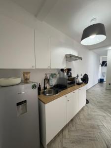 a kitchen with white cabinets and a refrigerator at Loft ËNXË Boutique Habitación Gray in Cuetzalán del Progreso