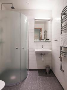 uma casa de banho com um chuveiro e um lavatório. em Ringsjöstrand Hotel em Hörby