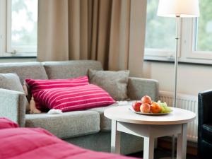 a living room with a couch and a table with a bowl of fruit at Ringsjöstrand Camping, Hotell och Stugby in Hörby