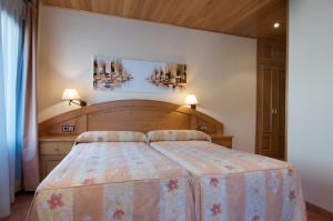 a bedroom with a large bed with a wooden headboard at Hotel Pey in Bohí
