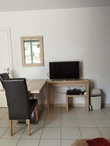 Μια τηλεόραση ή/και κέντρο ψυχαγωγίας στο Studio cosy avec terrasse dans résidence avec piscine, proche thermes et centre ville