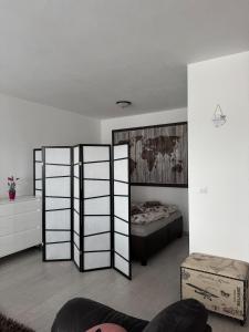a living room with a bed and two dividers at Beautiful apartment in the city center,with full amenities in Poprad