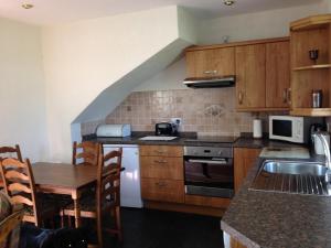 a kitchen with wooden cabinets and a wooden table with a tableablish at Eastwood Cottage in Turriff