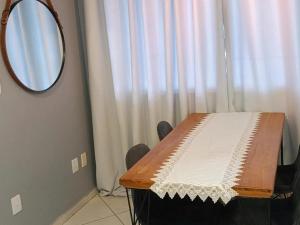 a room with a table with a mirror next to a window at Apart 3qtrs á 1200m da praia de Itapuã in Vila Velha