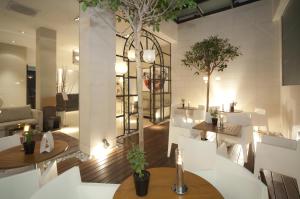 a restaurant with white chairs and tables and trees at Hotel Taburiente S.C.Tenerife in Santa Cruz de Tenerife