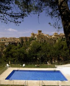 a large swimming pool in front of a large building at Parador de Cuenca in Cuenca