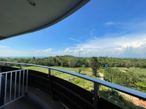 a balcony with a view of a golf course at The Nove Apartment Kalani Tower Sea View in Pulau Nongsa