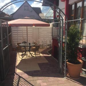 a patio with a table and an umbrella at Ferienwohnung Weiss in Rust