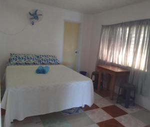 a bedroom with a bed and a table and a window at Tuki Beachfront and Surf Resort in Alegria