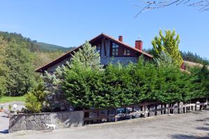 ein Haus mit Kiefern davor in der Unterkunft Hotel Antsotegi in Etxebarria