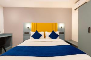 una camera da letto con un letto grande con cuscini blu e bianchi di Hotel Spring Stays Near US Consulate a Hyderabad