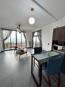 a living room with a table and blue chairs at Loft ËNXË Boutique Habitación Green in Cuetzalán del Progreso +24 photos