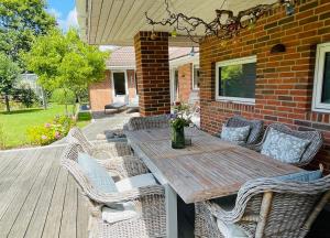 Ein Holztisch und Korbstühle auf einer Terrasse in der Unterkunft Villa Hygge in Haslev