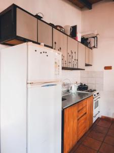 une cuisine avec un réfrigérateur blanc et des placards en bois dans l'établissement Depto Terraza & Confort, à Posadas 3 autres photos