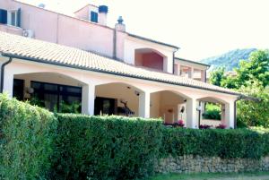 a house with a hedge in front of a building at Appartamenti Le Spiagge in Marciana Marina +13 photos
