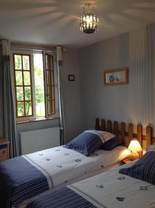 een slaapkamer met twee bedden en een raam bij L'Orchard in Bonneville-la-Louvet