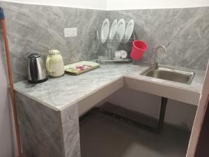 a kitchen counter with a sink and utensils at Nilanthi Guest House in Welimada