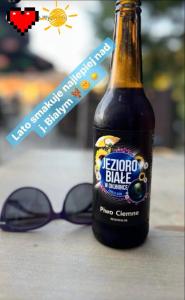 a bottle of beer next to a pair of glasses at Pokój u Julii in Okuninka