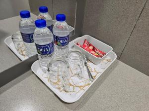 a tray with bottles of water and glasses on a counter at Laman D'Village in Kelebang Besar +4 photos