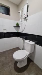a bathroom with a white toilet and a shower at Laman D'Village in Kelebang Besar