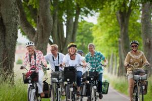 a group of people riding bikes down a road at Ringsjöstrand Camping, Hotell och Stugby in Hörby