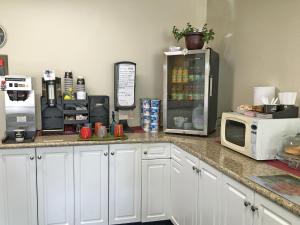 eine Küchentheke mit einer Mikrowelle und einem Kühlschrank in der Unterkunft Westgate Inn in Portage La Prairie