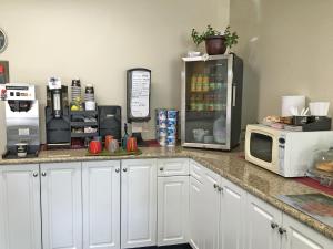 a kitchen counter with a microwave and a refrigerator at Westgate Inn in Portage La Prairie