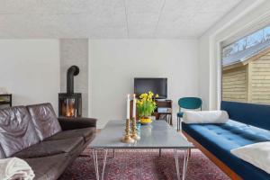a living room with a couch and a table at Holiday Home In 1St Row By The Limfjord in Thyholm