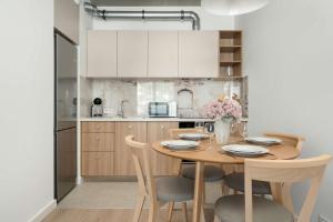 a kitchen with a wooden table with chairs and a dining room at Luxury Apartments with Parking and Air Conditioning near Wrocław City Center by Renters Prestige in Wrocław
