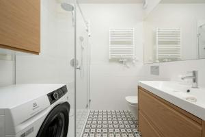 a white bathroom with a washing machine in it at Luxury Apartments with Parking and Air Conditioning near Wrocław City Center by Renters Prestige in Wrocław