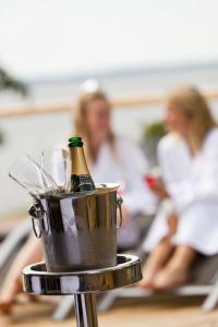 Una botella de champán en un cubo sobre una mesa en Ringsjöstrand Hotel, en Hörby