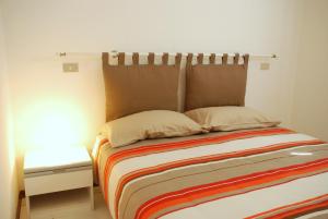 a bed with a headboard in a room with a table at Appartamenti Le Spiagge in Marciana Marina