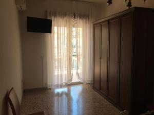 クロトーネにあるB&B Crotoneの大きな窓とドレッサーが備わる空の部屋