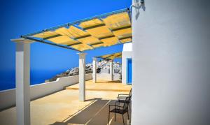 eine Terrasse mit Stühlen und Meerblick in der Unterkunft Villa Aigli in Anafi