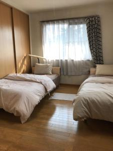 a bedroom with two beds and a window at 8-17 Nomura Motomachi - House / Vacation STAY 1893 in Hirakata