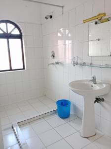 une salle de bain blanche avec un lavabo et une douche dans l'établissement Hotel Norbu Sangpo, à Katmandou 21 autres photos