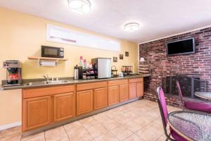 a kitchen with a counter with a sink and a fireplace at Relax Inn in Brunswick