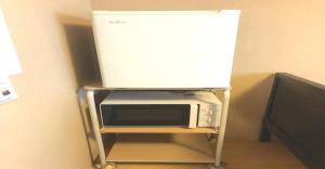 a microwave on a stand with a tv on top at 3-25-2 Higashiogu - Apartment / Vacation STAY 8348 in Tokyo